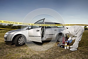 Collecting of evidences and traces by criminologist around car