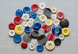 A collection of assorted buttons on a gray fabric background