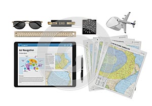 Collection of aviation tools including sunglasses, e6b flight computer, model airplane, maps, and tablet displaying air flow
