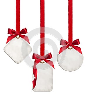 Collection of blank gift tags tied with red satin ribbon bows