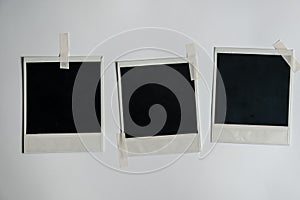 Collection of blank photo frames taped on white wall. Set of photos frame for your picture. Photo frame on a white