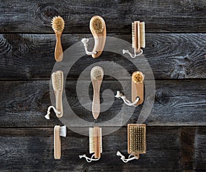 Collection of body brushes on old wood background, top view