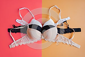 Collection of bras on pink and yellow background, top view