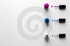 collection of bright bottles of nail polish and drop on white background