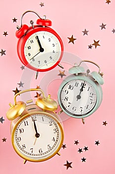 Collection of bright colorful alarm clocks over the pink background