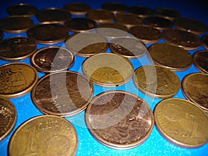 A collection of bronze eurocents on a blue background.