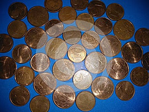 A collection of bronze eurocents on a blue background.