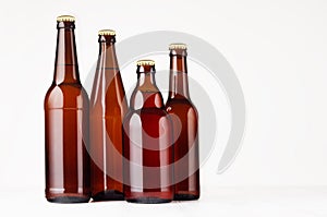 Collection brown beer bottles, mockup. Template for advertising, design, branding identity on white wood table.