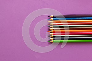 Collection of colored pencils on a purple background top view and copy space. Education, Back to school. Concept