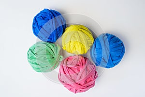 Collection of colored tangles from used rags on a white background, top view. Recycled knitting material.