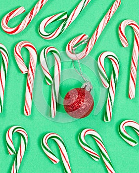 Collection of colorful candy canes and ornament on green backgro