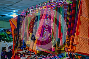 Collection of colorful sarees hanging in hangers in Indian shop