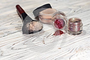 Collection of cosmetics for make-up artist. Powder, pigments, glitter, brushes and eyeliner. studio photo on a wooden background w