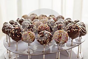A collection of delicious chocolate lollipops with various colourful sprinckles on top