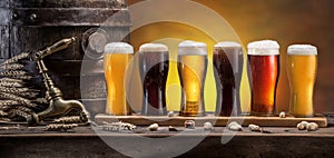 Collection of different chilled beer on wooden table. Cellar interior