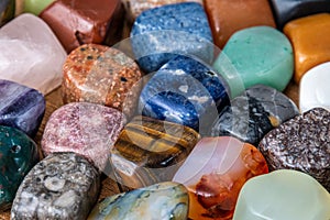 Collection of different colored polished gemstones an jewels pure luxury on wooden underground photo