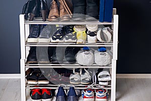 A collection of different shoes and sneakers of one family in a shoe rack