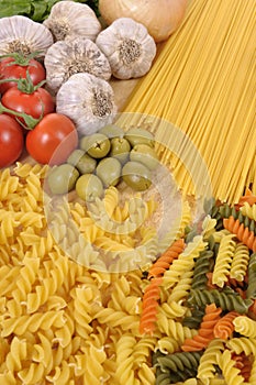Collection of different types of Italian pasta ingredients with garlic, olives and tomatoes