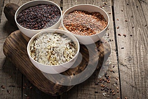 Collection of different varieties of rice on wooden rustic background