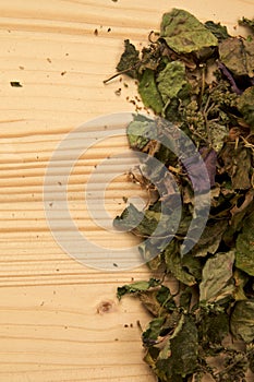 Collection of dried patchouli leaves and flowers on wood