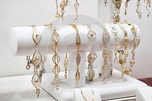 A collection of gold and silver filigree women\'s bracelets on display in a jewellery shop