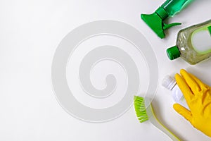 Collection of green and white cleaning supplies on white background. Detergents in plastic bottles. Flat lay. Close up