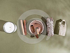 Collection items for spiritual cleansing - sage bundle, palo santo incense sticks, candle and quartz crystal