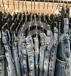 Collection of jeans hanging on a rack in a fashion boutique for sale