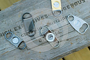 Collection of luxury cigar cutters placed on antique explosive box