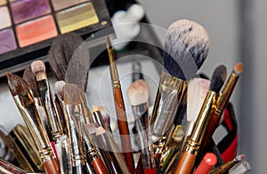 A collection of makeup brushes are displayed in a container
