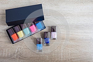 Collection of multi-colored bottles of nail polish. Layout for design on a gray background