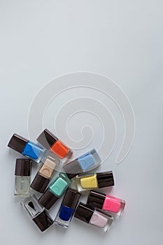Collection of multi-colored bottles of nail polish. Layout for design on a gray background