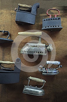 Collection of old metal clothes irons displayed on wall