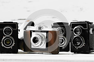 Collection old vintage retro photo cameras on white wooden background. top view, medium format