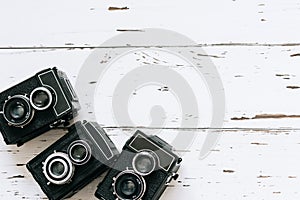 Collection old vintage retro photo cameras on white wooden background. top view, medium format