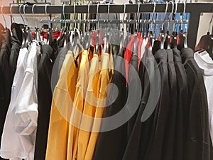 Collection outfit in hanging racks in clothing fashion store. Shirts