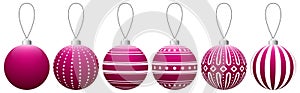 Collection of pink glass Christmas balls with a pattern hanging on a thread isolated on a white background.