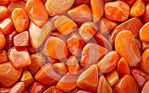 A collection of polished carnelian gemstones in a stunning array of warm orange, reddish-brown, and golden hues