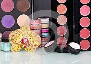 Collection professional cosmetics for makeup and orchid flower background.