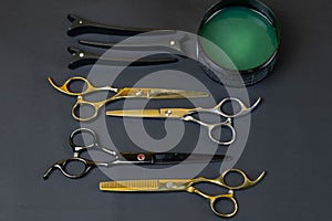 Collection of professional hair dresser tools arranged on dark background