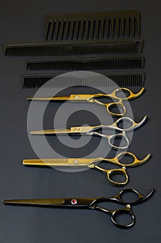 Collection of professional hair dresser tools arranged on dark background