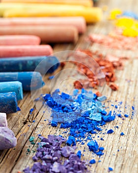 Collection of rainbow colored pastel crayons with crushed chalk.