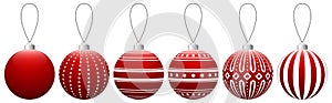 Collection of red glass Christmas balls with a pattern hanging on a thread isolated on a white background.