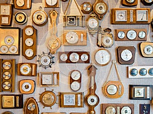 Collection of retro old barometers and watches hanging on a textured wall