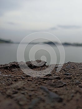 A collection of river rocks with a river and clear sky in the background