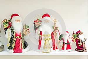 Collection of Santa Clauses on a shelf. Symbol of christmas and New Year Holidays