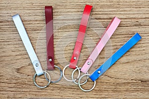 Collection set of colorful Leather key chain on wooden background.