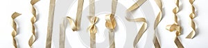 Collection of shiny golden ribbons with different shapes on white