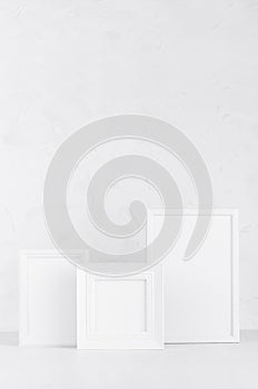 Collection of simple modern different white wood blank photo frames on wood board in gentle simplicity soft light interior.