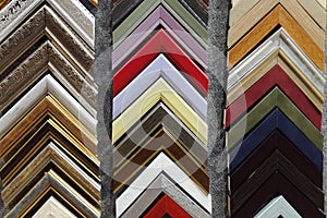 A collection of solid wood photo picture frame corner samples are displayed on a table